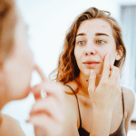 Kosmetik Schwäbisch Gmünd 02_Unreinehaut_close-up-of-a-young-woman-looking-at-pimples-in-th-2024-03-05-16-02-38-utc-2